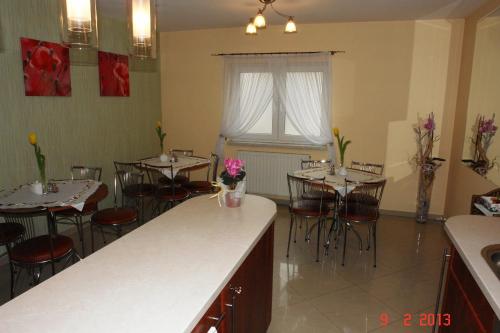 a restaurant with tables and chairs with flowers on them at Pokoje Hotelowe Wiktoria in Goczałkowice Dolne