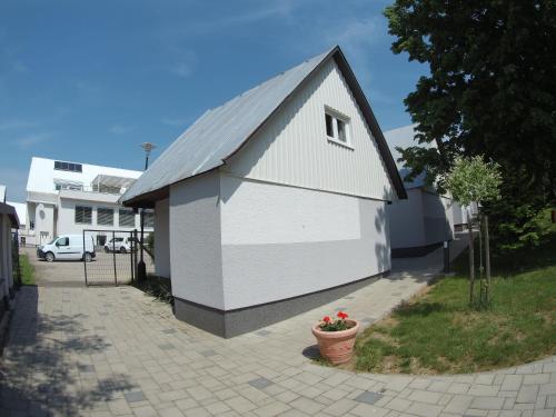 a small white building with a pitched roof at Chaty - Resort AQUA MARIA in Veľaty