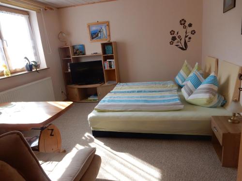a bedroom with a bed and a tv in it at Zum Stadtwald in Spremberg