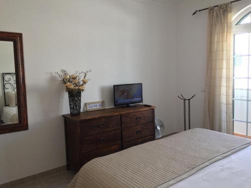 a bedroom with a bed and a television on a dresser at SS Tavira in Cabanas de Tavira