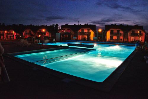 a large swimming pool at night with lights at Apartament Makowe Pola in Żarnowska