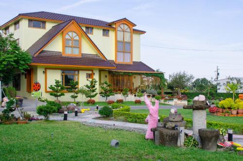 a house with a pink statue in front of it at XinFu Traveler Inn in Taiping