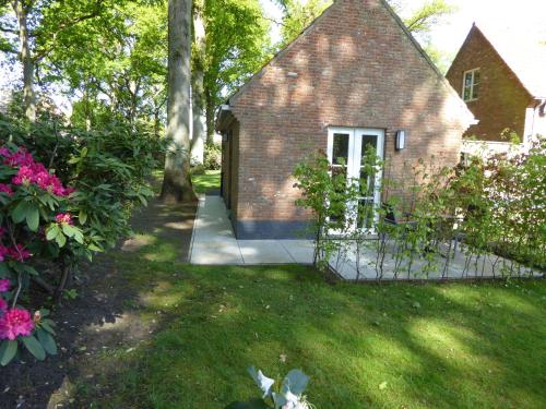 a brick house with a gate in a yard at B&B Goudvink in Schilde
