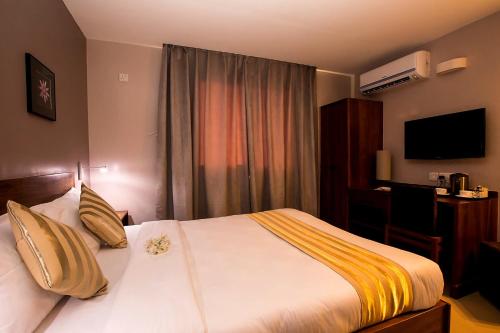 a hotel room with a bed and a desk at Venus Premier Hotel in Arusha