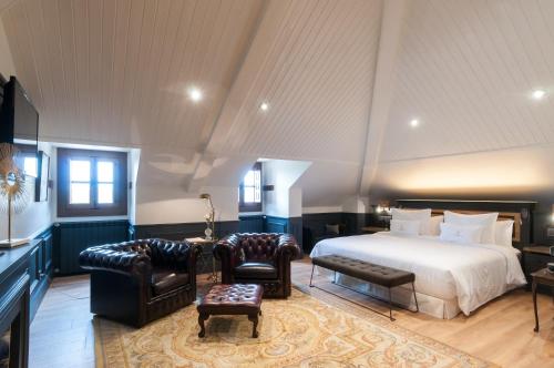 a bedroom with a bed and two chairs and a table at La Casa del Presidente in Avila