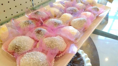 a bunch of pastries in pink packets on a shelf at Hotel Modern Puli in Puli