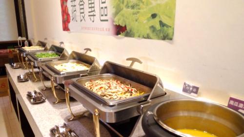 a row of trays of food on a counter at Hotel Modern Puli in Puli