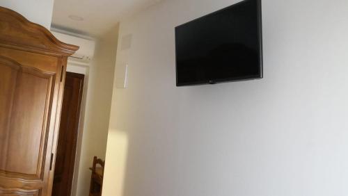 a flat screen tv hanging on a wall at Madrid Playa Rooms in Madrid