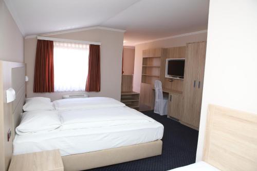 a hotel room with a bed and a television at Hotel Ana in Gospić