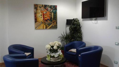 a waiting room with two blue chairs and a tv at Residence Delta in Rovigo