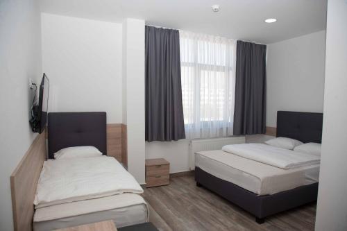 1 Schlafzimmer mit 2 Betten und einem Fenster in der Unterkunft Apartments R Sport boutique in Sarajevo