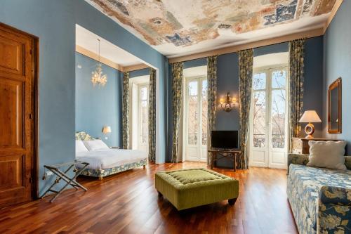 a bedroom with blue walls and a bed and a couch at Bellezza Suites in Cagliari