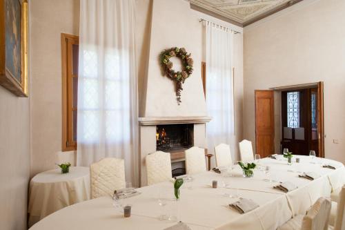 a dining room with white tables and a fireplace at Hotel Villa Ca' Sette in Bassano del Grappa