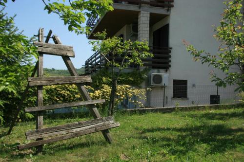 drewniana ławka na trawie przed domem w obiekcie Apartma Tul w mieście Izola