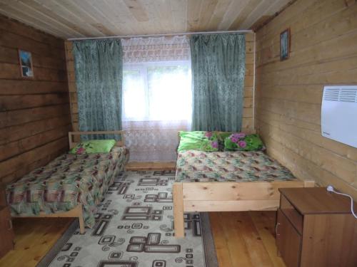 アルティバシュにあるSokol Guest Houseのベッド2台と窓が備わる小さな客室です。