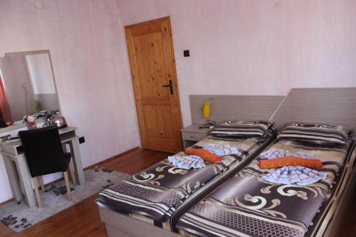a bedroom with two beds and a desk and a desk at Guest House Dara in Tsarevo