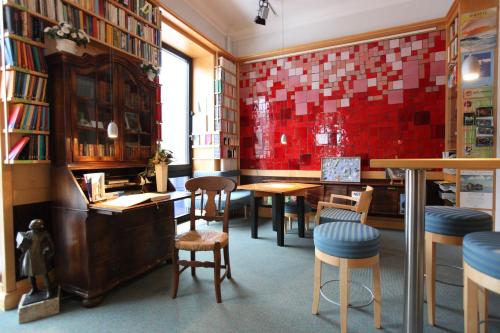 a restaurant with tables and chairs and a red wall at Hotel Niedersachsen in Westerland (Sylt)