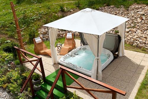 a hot tub in a tent with an umbrella at Hrabovo Lake View Apartment in Ružomberok
