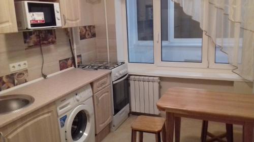 eine Küche mit einer Spüle und einer Waschmaschine in der Unterkunft Apartment on Rusanivska 16 in Kiew