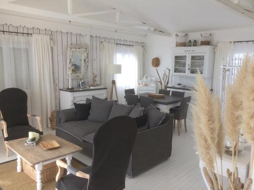 a living room with a couch and a table at Holiday home Chalet Pleine Vue Sur Mer in Gruissan