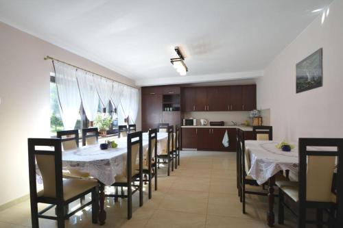 een eetkamer met tafels en stoelen en een keuken bij Gospodarstwo Agroturystyczne Watra in Koninki