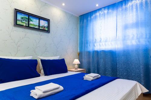ノヴィ・ウレンゴイにあるFive Stars Comfortの青いベッドルーム(タオル付きのベッド付)