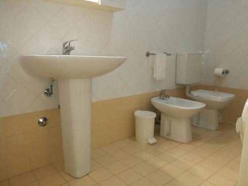 een badkamer met een wastafel en een toilet bij Villa Rossella in Porto Santa Margherita di Caorle