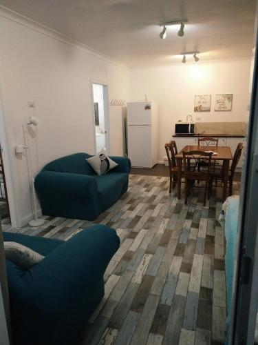 a living room with a blue couch and a table at Busselton Ithaca Motel in Busselton