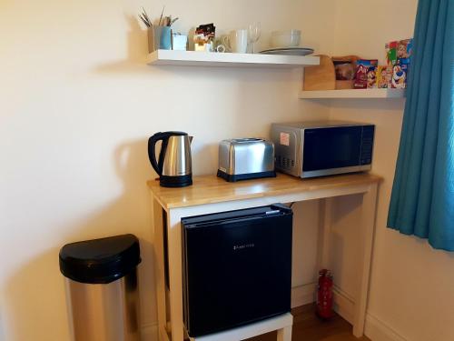 a table with a microwave and a coffee maker on it at Primrose House in St Ives