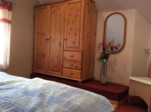 クルムホルンにあるFerienwohnung Everwienのベッドルーム(ドレッサー、鏡、ベッド付)