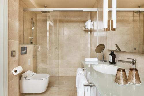 a bathroom with a sink and a toilet and a shower at Hotel St. George Helsinki in Helsinki