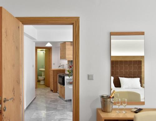 a room with a bed and a kitchen with a mirror at Artemis Hotel Apartments in Hersonissos