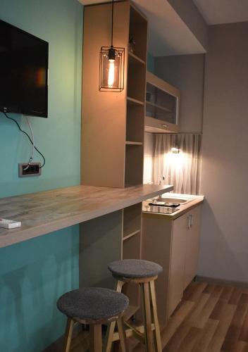 a kitchen with two bar stools and a counter at Apartmani Zrenjanin in Zrenjanin