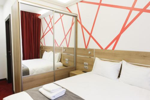 モスクワにあるKANNAのベッド2台と鏡が備わるホテルルームです。