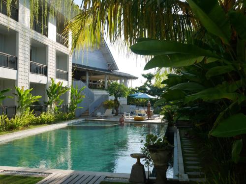 a large swimming pool in front of a large building at Padang-Padang Inn in Uluwatu