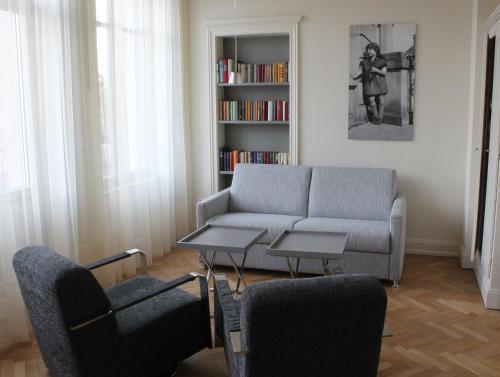 a living room with a couch and a book shelf at Villa Élyane in Colmar
