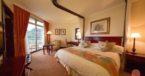 a hotel room with a bed and a large window at Lake Kivu Serena Hotel in Gisenyi