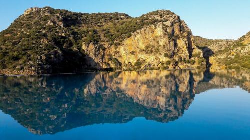 a reflection of a mountain in the water at Enagron Ecotourism Village in Axós