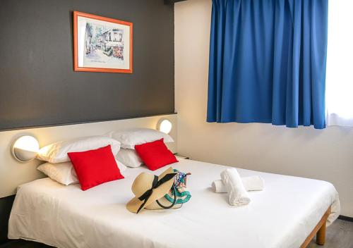 ヴィシーにあるHôtel des Thermes Callouのベッドルーム1室(ベッド2台、赤と白の枕付)