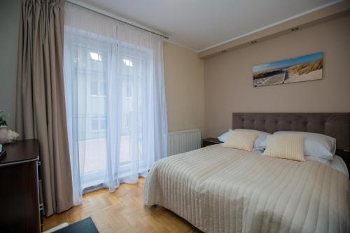 a bedroom with a bed and a large window at Savona Świnoujście in Świnoujście