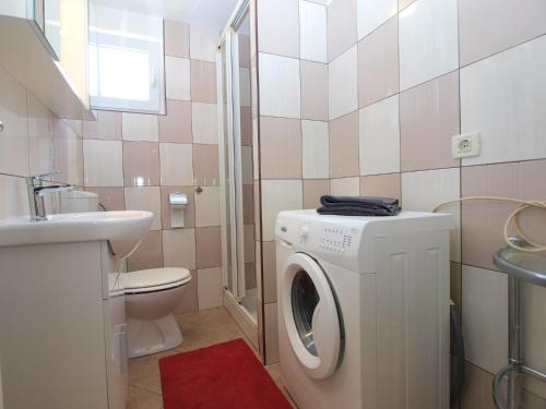 a bathroom with a washing machine and a sink at Apartment Vera 1623 in Fažana