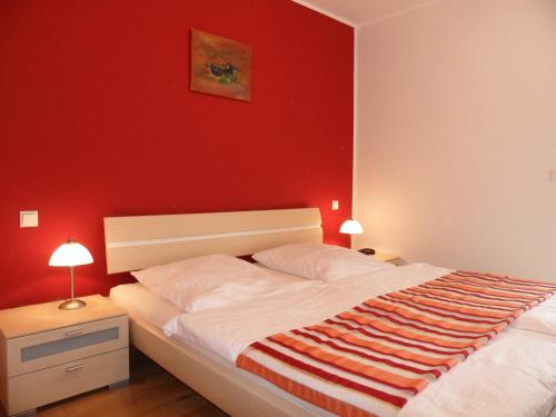 a bedroom with a bed with a red wall at Schloonseevilla mit Tiefgarage - 200 m zum Strand in Heringsdorf