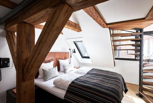 a bedroom with a large bed with wooden beams at 71 Nyhavn Hotel in Copenhagen