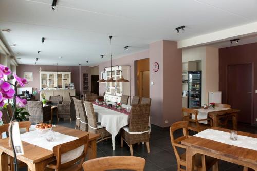 a dining room with wooden tables and chairs and a table at B&B La Vie En Roses in Moorsel