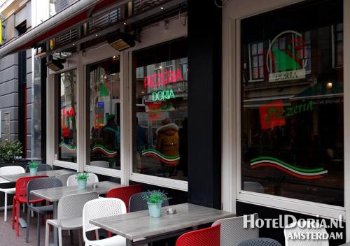 a restaurant with tables and chairs in front of a window at Hotel Doria in Amsterdam