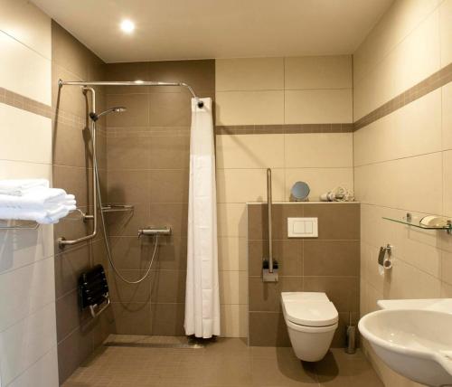 a bathroom with a shower and a toilet and a sink at B&B La Vie En Roses in Moorsel