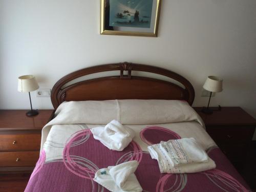 sypialnia z łóżkiem i dwoma ręcznikami na nim w obiekcie Apartamento en Terra do Porto con vistas w mieście O Grove