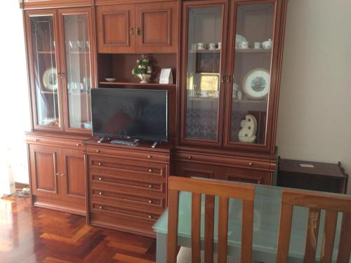 duże drewniane centrum rozrywki z telewizorem w salonie w obiekcie Apartamento en Terra do Porto con vistas w mieście O Grove