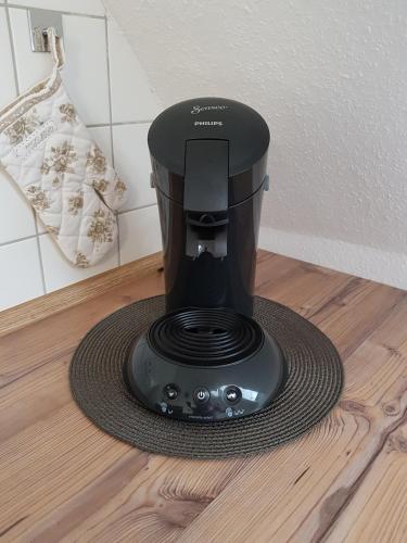 a black coffee maker sitting on a floor at Apartment Kirschblüte in Appenweier