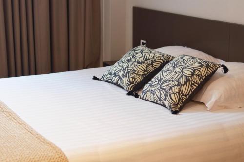 a bed with two pillows on top of it at Hotel Le Sevigne - Sure Hotel Collection by Best Western in Rennes